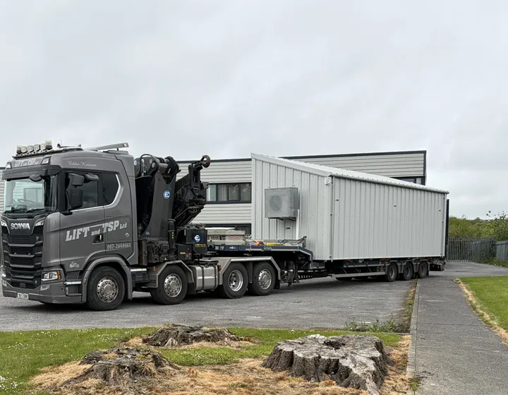 Crane-mounted truck delivering a container